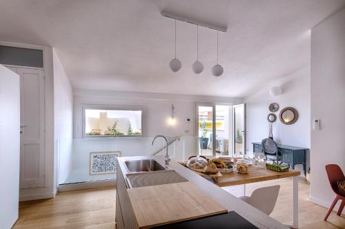 a living room with a table and a kitchen at Bisu Isola di Sant'Antioco in SantʼAntìoco