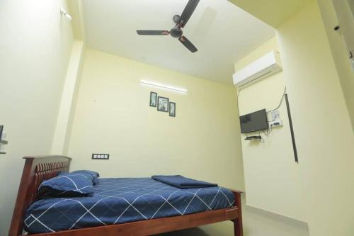 una camera con letto e ventilatore a soffitto di The Delux Cabin a Karaikkudi