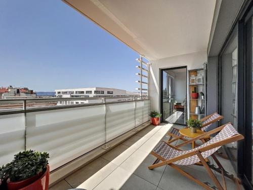 un balcon avec deux chaises et une table sur un immeuble dans l'établissement Sunrise du Panier - Climatisation & Central - Les Frères de la Loc', à Marseille