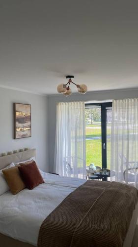 a bedroom with a large bed and a window at Three By The Sea apartments at Albatross Home in Ķesterciems
