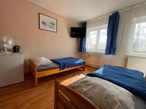 una camera con due letti e una tv di CBC Pokoje Hotelowe a Starogard Gdański