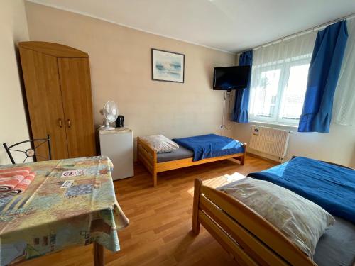 a small room with two beds and a table at CBC Pokoje Hotelowe in Starogard Gdański