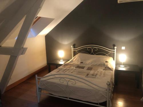 a bedroom with a bed with two lights on two tables at Au repère de la Truffe in Campagne