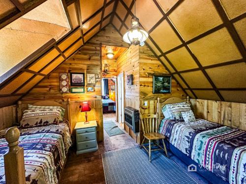 een slaapkamer met 2 bedden in een blokhut bij Off-grid Cabin At Angel Valley Ranch in Duck Creek Village