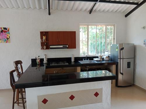 una cucina con piano di lavoro nero e frigorifero di CASA CORAL a La Mesa