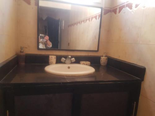 a person taking a picture of a sink in a bathroom at hay massira 4 in Dakhla