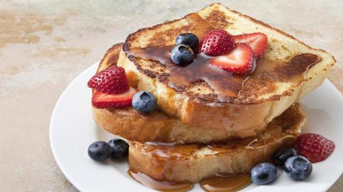 a plate of french toast with strawberries and blueberries at Hotel Boutique Siete Lunas in Sayulita