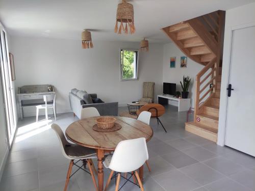 un salon avec une table et des chaises en bois dans l'établissement maison neuve 4 ou 5 personnes Kerguen, à Plobannalec-Lesconil