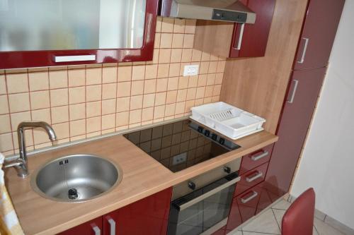 a small kitchen with a sink and a mirror at Apartment Love Smast in Kobarid