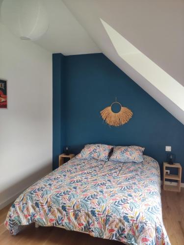 une chambre avec un lit avec un mur bleu dans l'établissement maison neuve 4 ou 5 personnes Kerguen, à Plobannalec-Lesconil