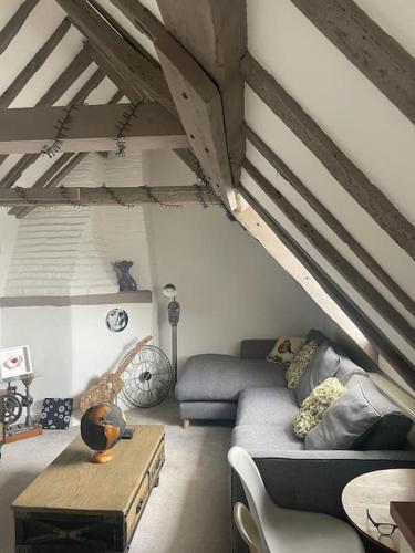a living room with a couch and a table at Beautiful 1600’s loft apartment. in Ware