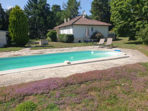 une piscine avec deux chaises et une maison dans l'établissement Reposant, arboré, confort, clos, bien équipé, Beauval, Châteaux, à Selles-sur-Cher