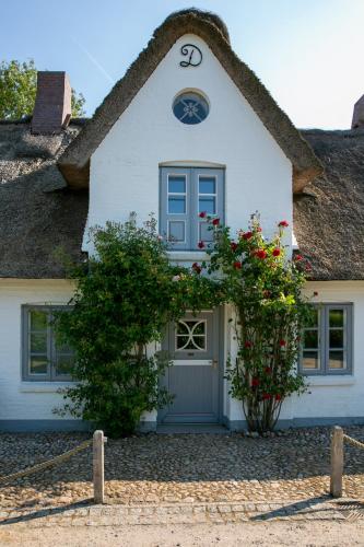 a white house with a thatched roof at Ferienhaus Midlum in Midlum