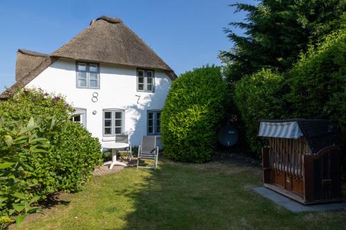 a large white house with a thatched roof at Ferienhaus Midlum in Midlum