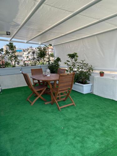 a table and chairs on a patio with green carpet at MohalaB&B in Bacoli