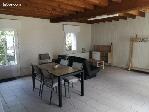 un salon avec une table, des chaises et un canapé dans l'établissement Vieux-Port à 45600 Bouteille, à Guilly