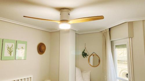 a ceiling fan in a room with a window at La casita de las campanas in Cenicero
