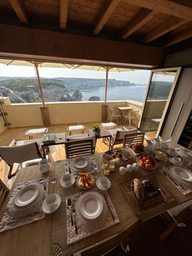 una mesa con comida y vistas al océano en Entre Ciel et Mer hotel, en Bonifacio