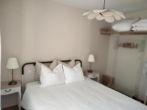 a bedroom with a white bed with white pillows at Maisonnette Familiale proche du PUYDUFOU in Les Épesses