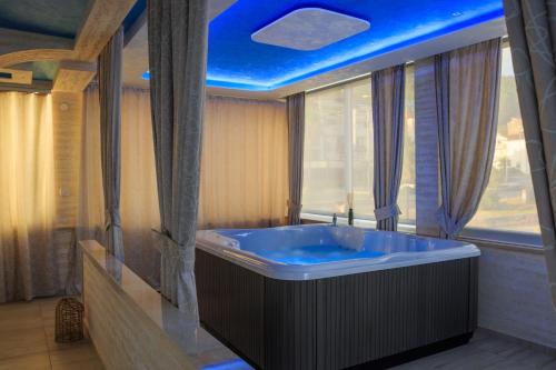 un bagno con una grande vasca e un soffitto blu di Hotel Maksim a Herceg-Novi