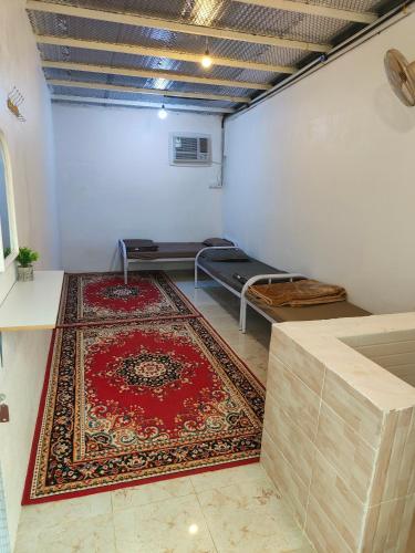 una camera con un tappeto rosso sul pavimento e un letto di استراحة a Al Maraghah