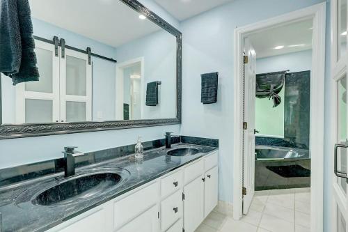 a bathroom with two sinks and a large mirror at Chateau Grove in Port Saint Lucie