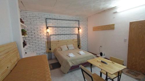 a small room with a bed and a table at Los Cardones - Ruta40 in Chilecito