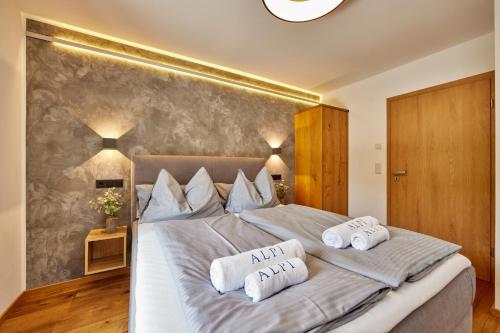 a bedroom with a large bed with two pillows on it at Private Spa & Garden Alpi in Garmisch-Partenkirchen