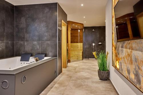 a bathroom with a soaking tub and a walk in shower at Private Spa & Garden Alpi in Garmisch-Partenkirchen