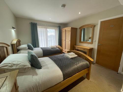 a hotel room with two beds and a mirror at Redwood Lodge in Penrith