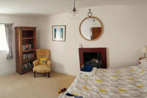 里士滿的住宿－Rose Cottage. Richmond, North Yorkshire，一间卧室配有一张床、一把椅子和镜子
