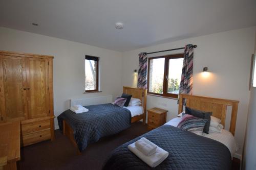 a bedroom with two beds and a window at Aikbeck Lodge in Penrith