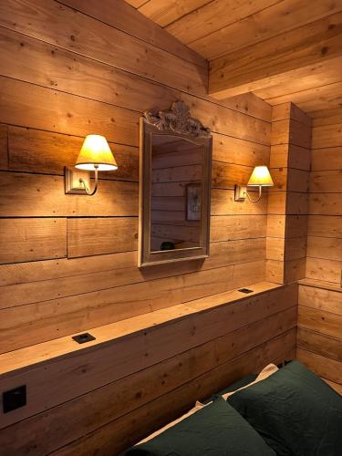 um quarto com paredes de madeira, um espelho e luzes em Le Chalet em Les Sorinières