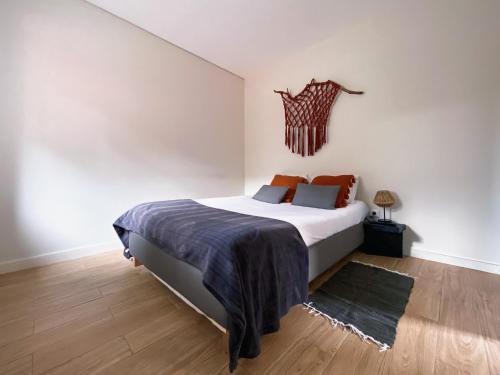 1 dormitorio con 1 cama blanca grande y suelo de madera en Casas S. Dinis, en Oporto