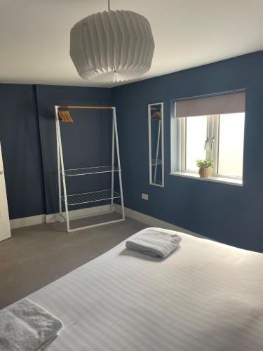 a blue room with a bed and two windows at 18 All Saints Passage in Huntingdon