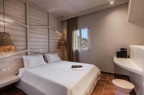 a bedroom with a white bed and a window at Kimolia Gi in Kimolos