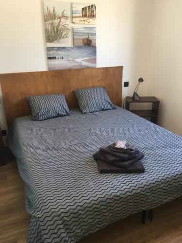 - un lit avec une couette et des oreillers bleus et blancs dans l'établissement Maison aux pieds des Alpilles, à Noves