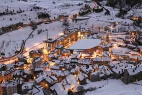 a town covered in snow at night with lights at APARTAMENTO CANILLO Wifi-Parquing free-Terraza HUT 5213 in Canillo