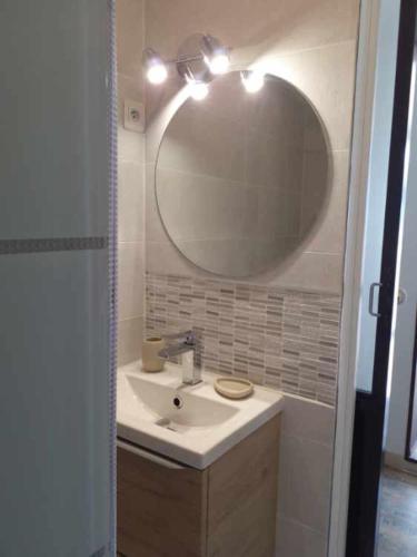 une salle de bain avec un lavabo et un grand miroir dans l'établissement LE CABANON REVISITÉ très beau T2 labellisé 3 ÉTOILES de 40m2 face au PORT de CARRY le ROUET, à Carry-le-Rouet