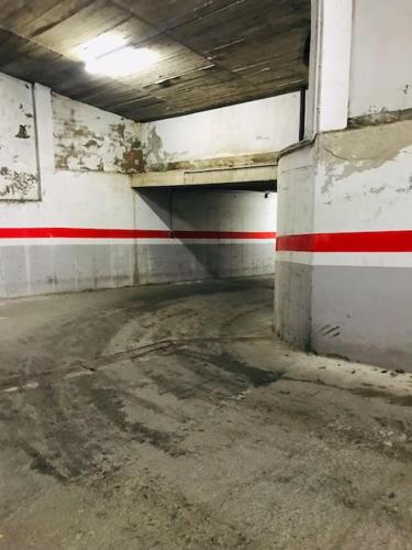 an empty parking garage with a red stripe on the wall at APARTAMENTO CANILLO Wifi-Parquing free-Terraza HUT 5213 in Canillo
