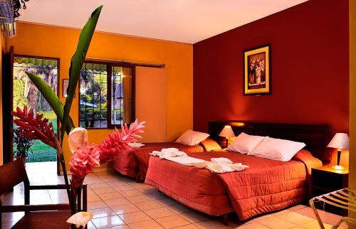 Un pat sau paturi într-o cameră la Cesar's Tropical Hotel