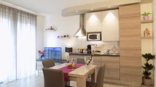 a kitchen and dining room with a table and a laptop at MillyHolidays - Apartment Lillà - Center - Nearby Beach - Private Garden - Spa Pool in Bardolino