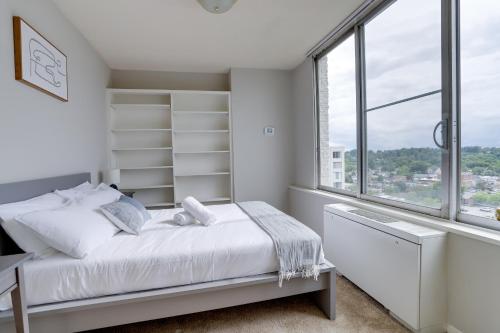 a white bedroom with a bed and a window at Fantastic 2 BR Apt + Den @Crystal City With Gym in Arlington