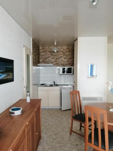 een keuken met een tafel en 2 stoelen in een kamer bij appartement saint hilaire de riez 85270 in Saint-Hilaire-de-Riez
