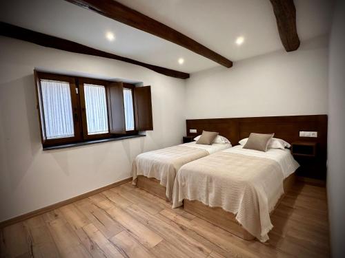 - 2 lits dans une chambre avec 2 fenêtres dans l'établissement La Casina de la Yeye San Cristóbal de Valdueza, à San Cristóbal de Valdueza