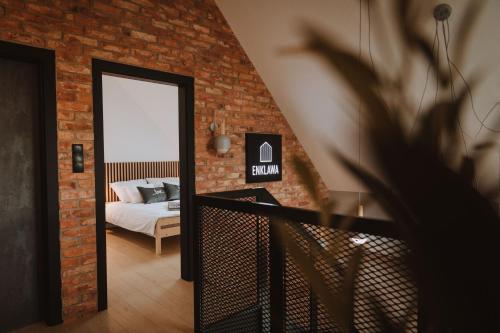 a bedroom with a bed and a brick wall at Enklawa in Nowy Podleś