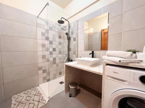 een badkamer met een wastafel en een wasmachine bij Casa Sossego in Lagos