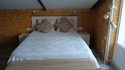 a bedroom with a bed with white sheets and pillows at Casa Gabriel in Picassent
