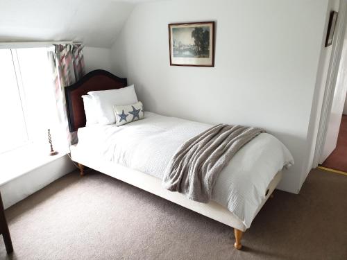 a white bed in a room with a window at Cottage in Frogmore near Salcombe Estuary & Beaches in Kingsbridge