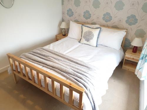 a bedroom with a bed with white sheets and pillows at Cottage in Frogmore near Salcombe Estuary & Beaches in Kingsbridge